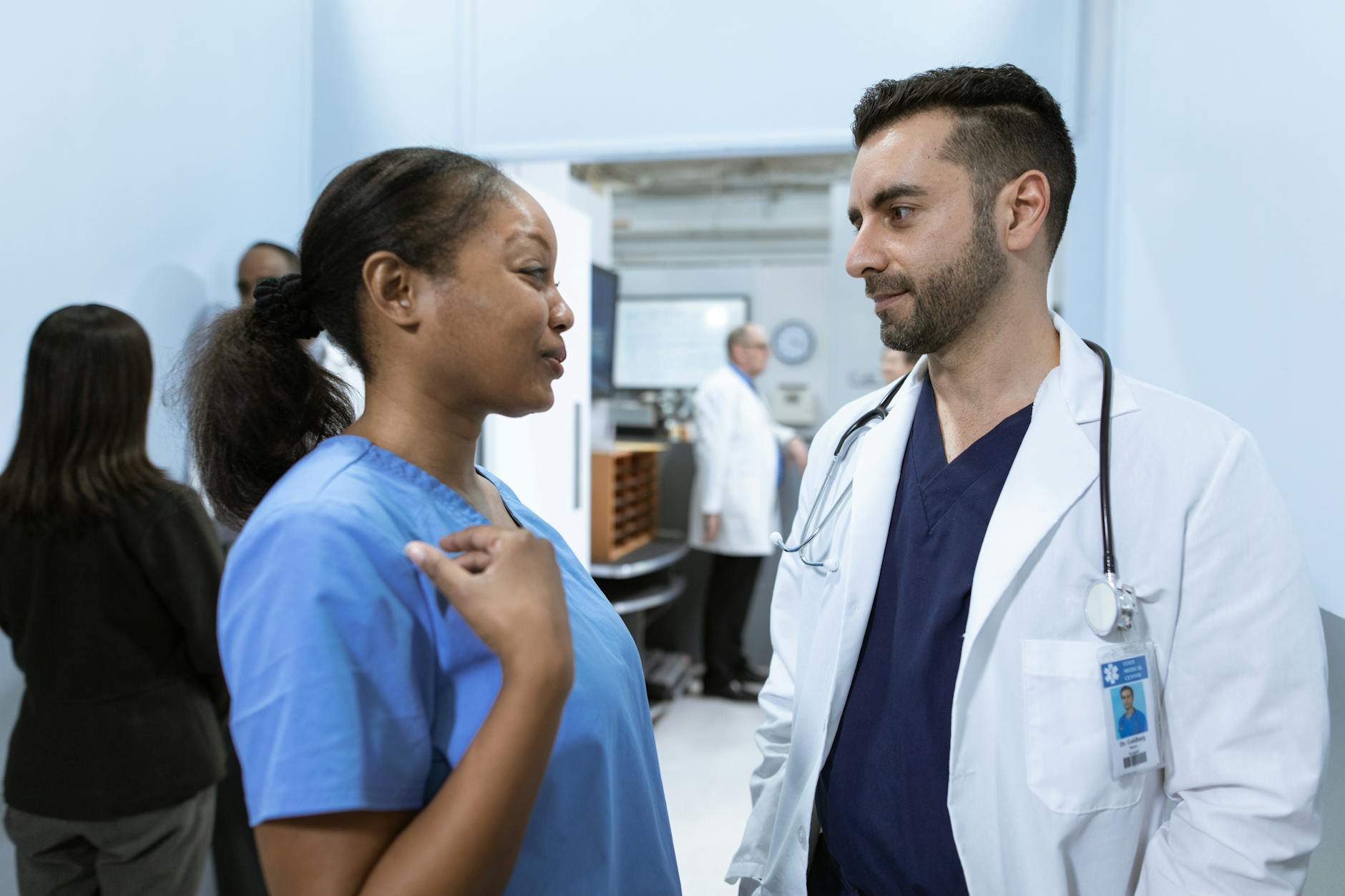 A diverse group of medical professionals collaborating around a large, interactive screen displaying complex patient data visualizations and AI-generated insights.