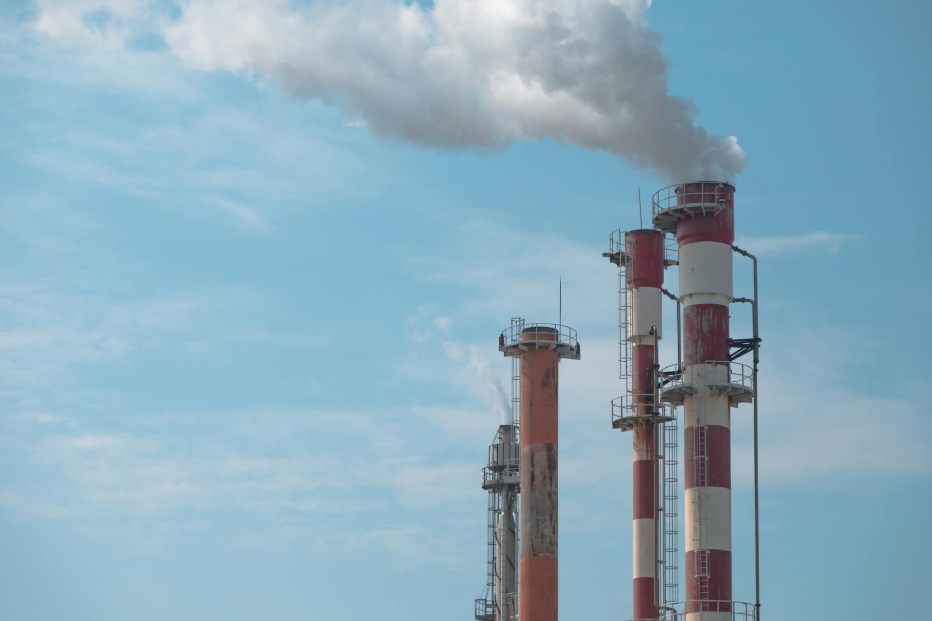 A complex infographic illustrating the global carbon cycle and how CCUS technologies intercept CO2 emissions from various industrial sources before they reach the atmosphere.