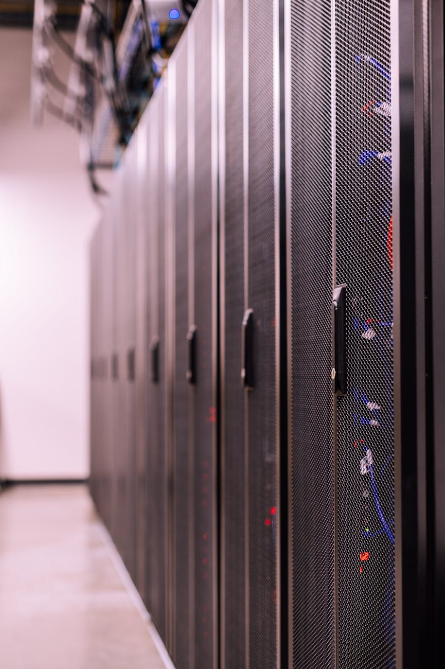 A high-angle view of a sleek, minimalist cloud data center, bathed in ethereal blue light, with abstract data streams flowing, representing the foundational infrastructure for cloud robotics.