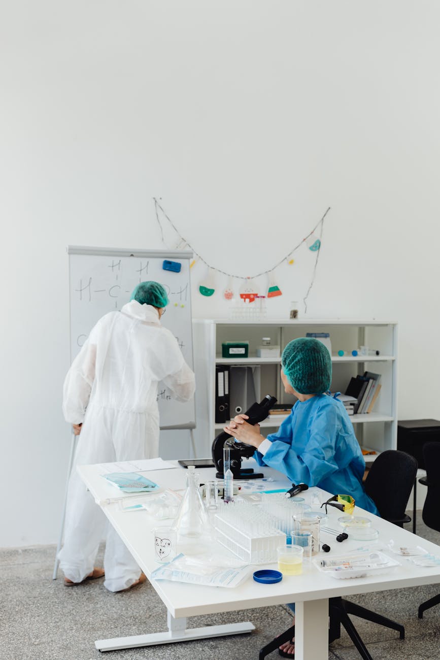 A highly detailed, futuristic laboratory scene with glowing microfluidic devices representing organs on a chip, scientists in advanced sterile suits observing data on holographic displays.