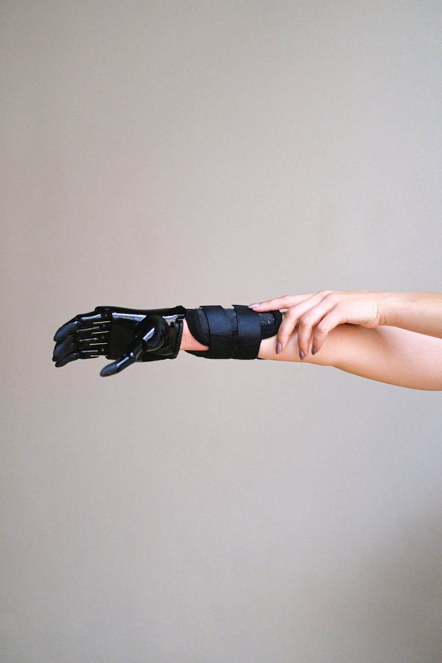 A patient with a sophisticated, subtle BCI device seamlessly integrated with a robotic prosthetic arm, demonstrating fluid, thought-controlled movement in a modern rehabilitation center. The patient has a look of empowerment.