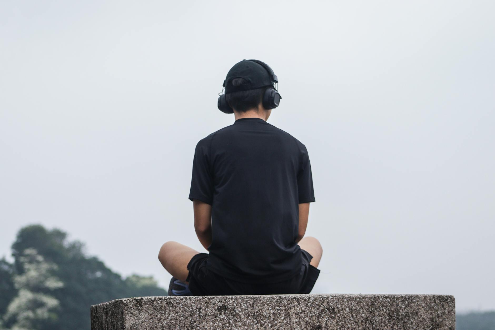 A person wearing a minimalist, elegant BCI headband, meditating in a serene environment, with subtle neural activity visualizations emanating around them.