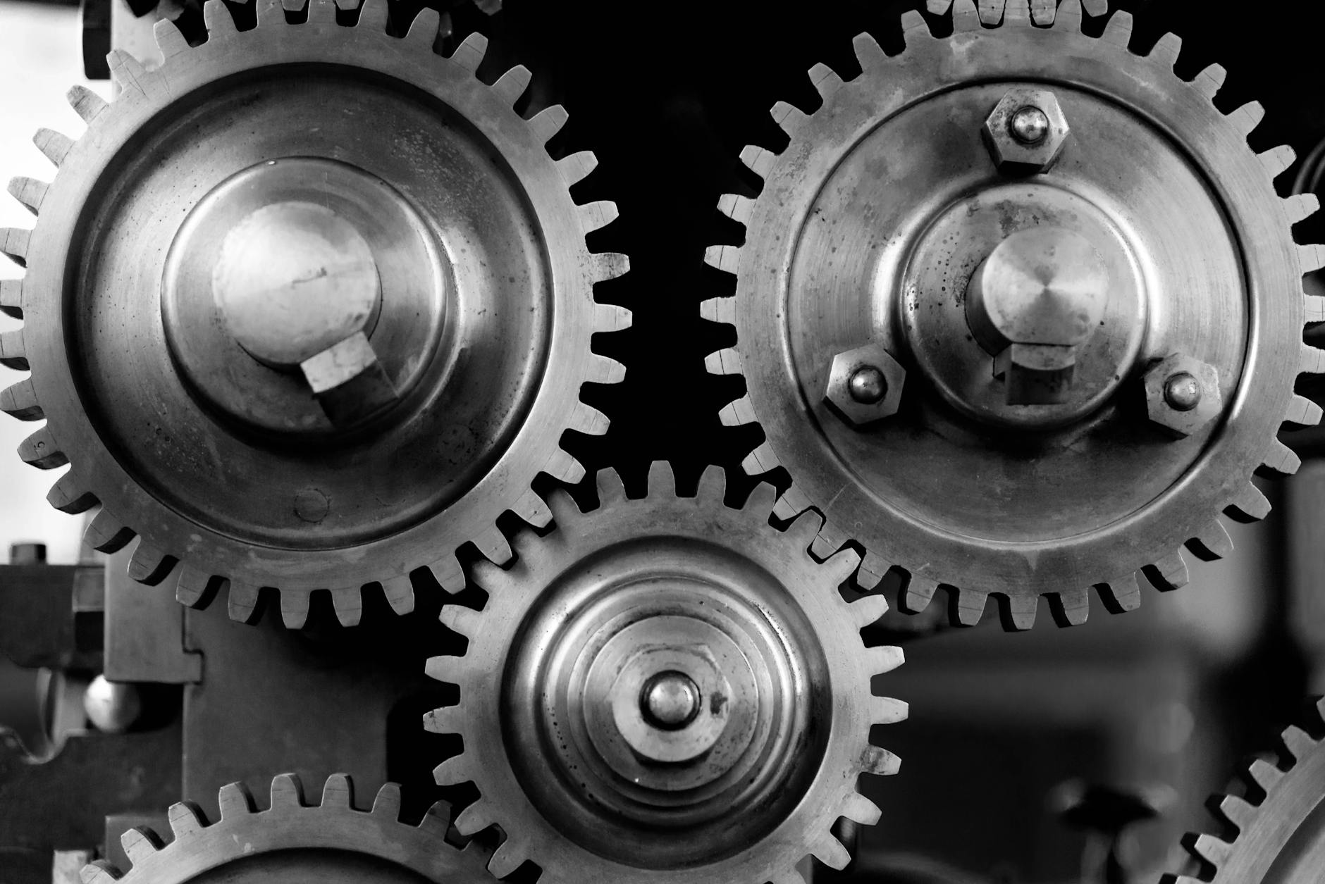 A close-up of a complex industrial gear, with glowing lines indicating stress points predicted by an AI overlay.