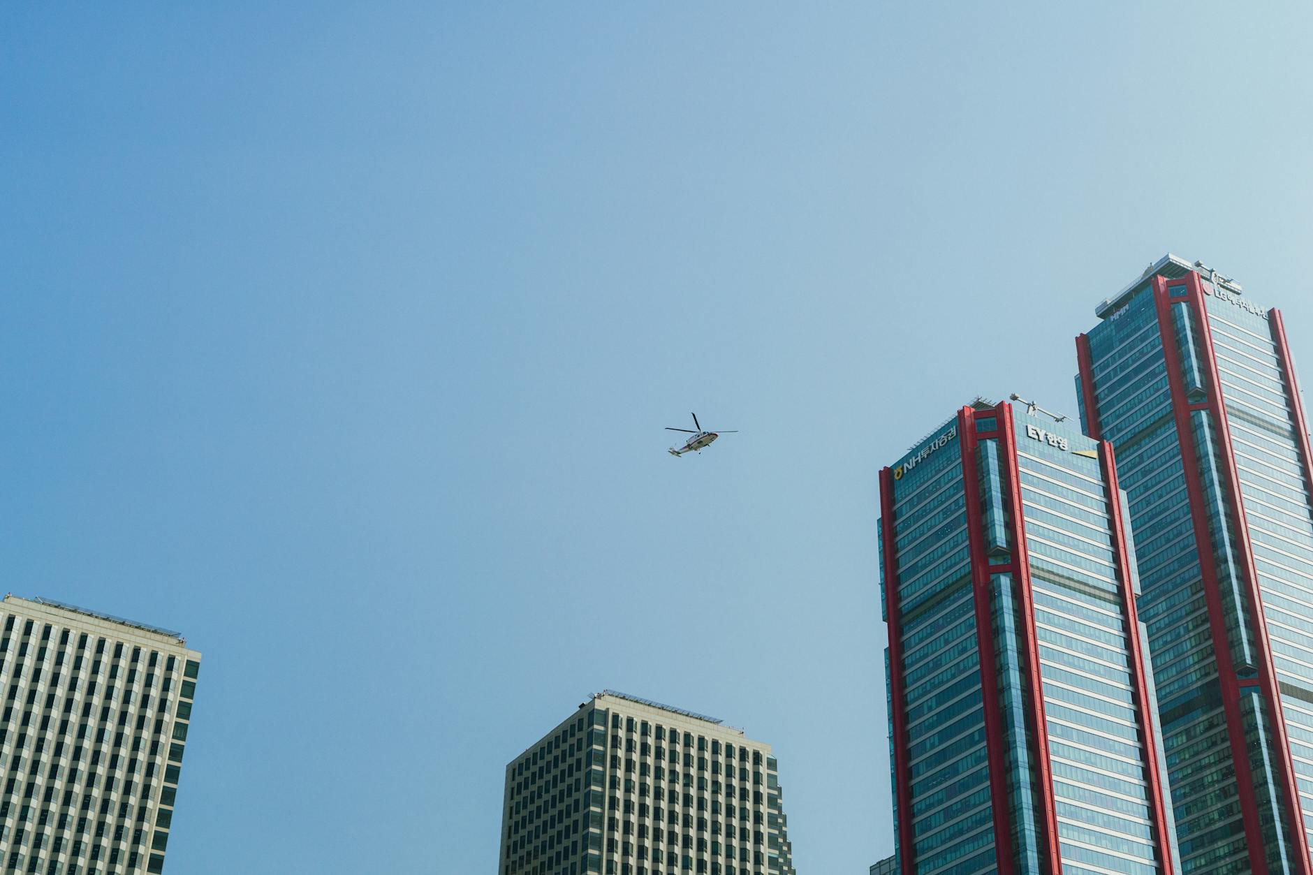 A stylized image of a Korean city, perhaps Seoul, with K-UAM branded eVTOLs taking off from a prominent vertiport, representing national initiatives and the integration of UAM into the urban fabric.