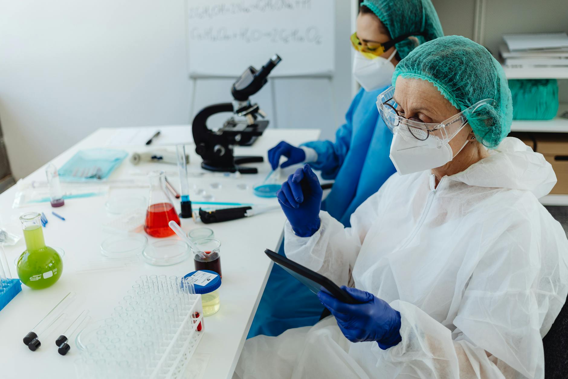 A futuristic medical laboratory with scientists in clean suits working with holographic displays showing complex biological data and AI algorithms.