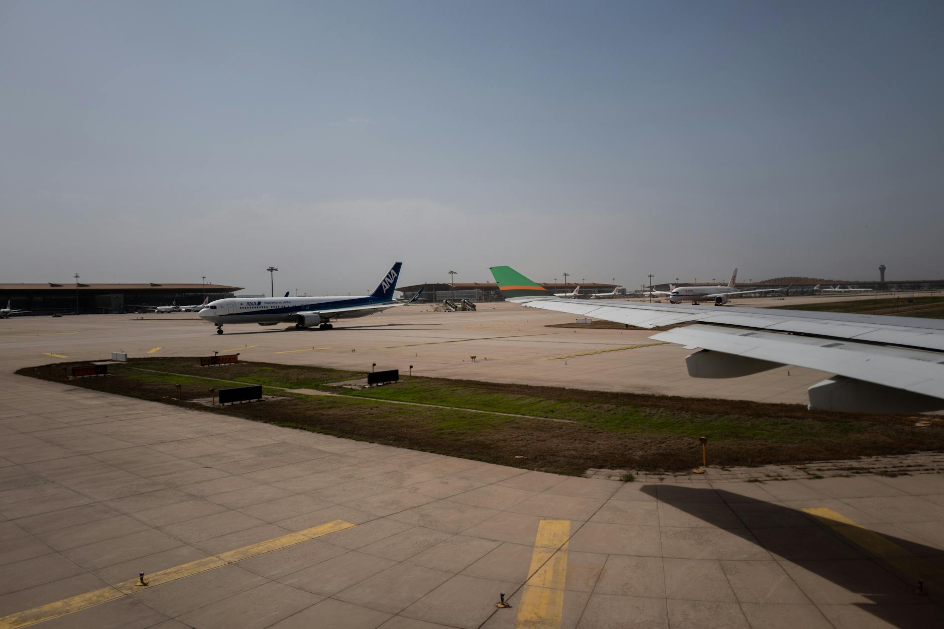 A panoramic view of a futuristic airport hub with multiple aircraft types (including SAF-powered, electric, and hydrogen concepts) seamlessly integrated, symbolizing global connectivity and sustainability.