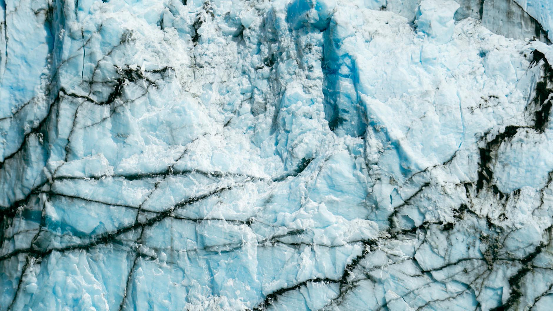 A detailed satellite image of an Antarctic ice shelf, with AI-generated annotations highlighting areas of potential fracture and melt, alongside real-time data readouts.