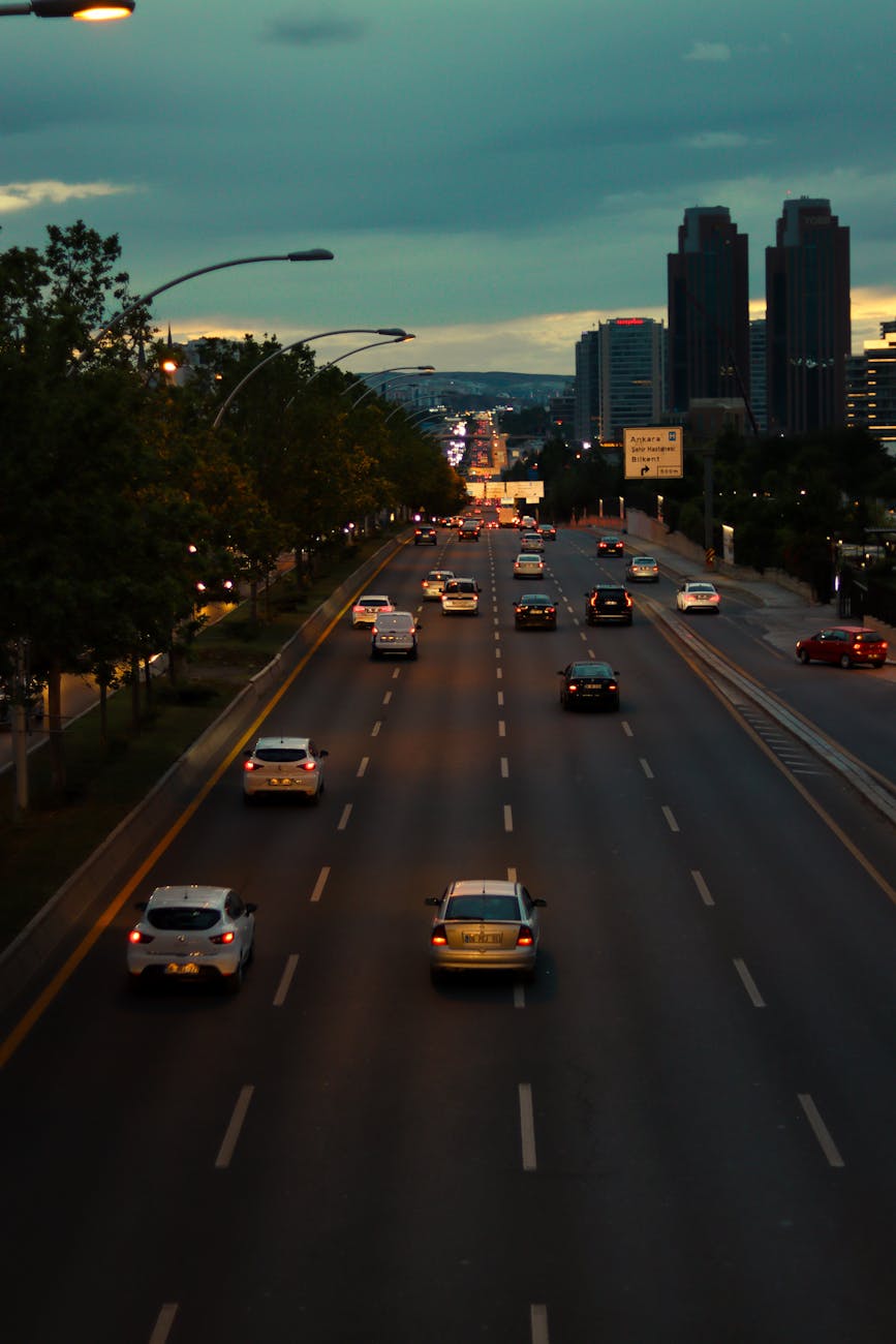 A vibrant city skyline at dusk, with a prominent display of green hydrogen fueling stations and FCEVs interspersed with electric vehicles, symbolizing a multi-modal clean transportation ecosystem.