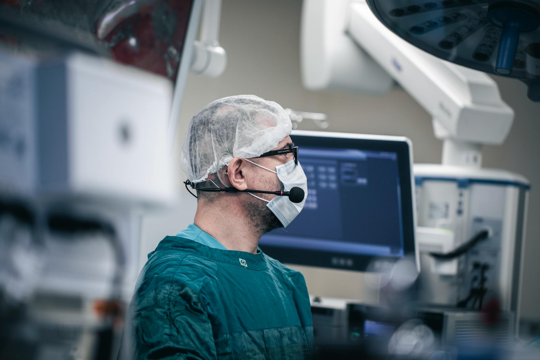 A surgeon, wearing augmented reality goggles, operates a haptic feedback console. On a large holographic display in front of them, a swarm of glowing nano-robots performs a delicate, precise surgical repair on a magnified organ, guided by AI.
