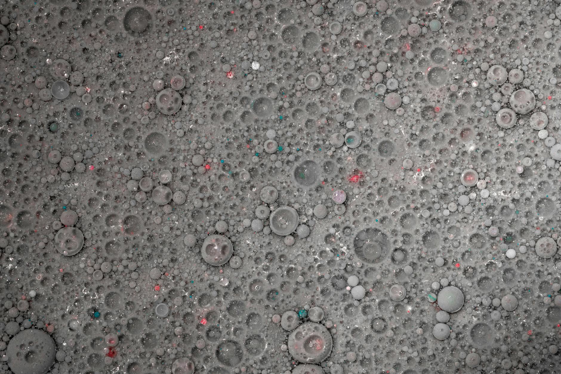 A detailed close-up of a nano-robot engaging with a single cancerous cell, demonstrating targeted destruction or drug delivery. The scene is highly magnified, showing intricate molecular interactions, with subtle AI indicators.