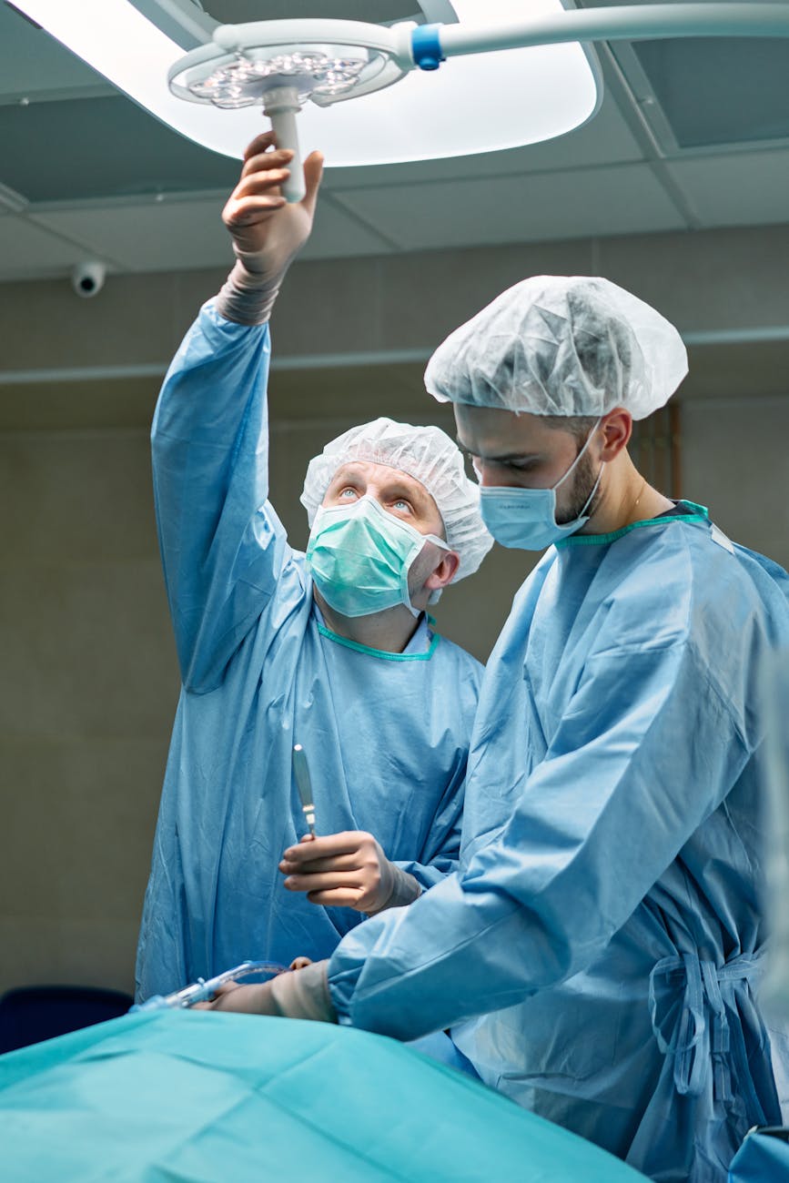 A diverse group of medical professionals in a modern operating room, collaborating and observing a holographic display of a nano-robotic surgical procedure.