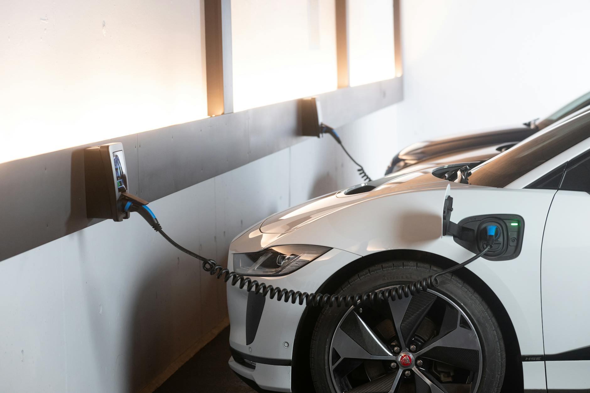 A futuristic smart home seamlessly integrated with solar panels, an electric car charging, and a home battery storage unit, all connected to a larger community grid, illustrating the microgrid concept. The scene is bright and optimistic.