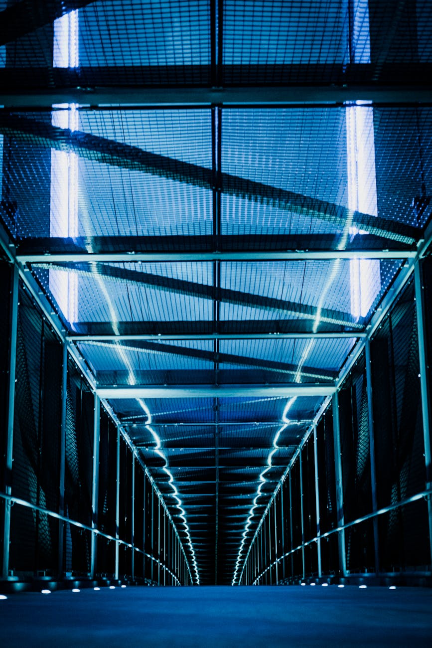 A futuristic, high-angle shot of a sprawling smart factory floor, bathed in cool blue and white light, with multiple sleek AMRs seamlessly navigating complex pathways, carrying glowing cargo. The factory is clean, highly automated, and hints at advanced AI integration. Text overlays or holographic elements could show data streams.