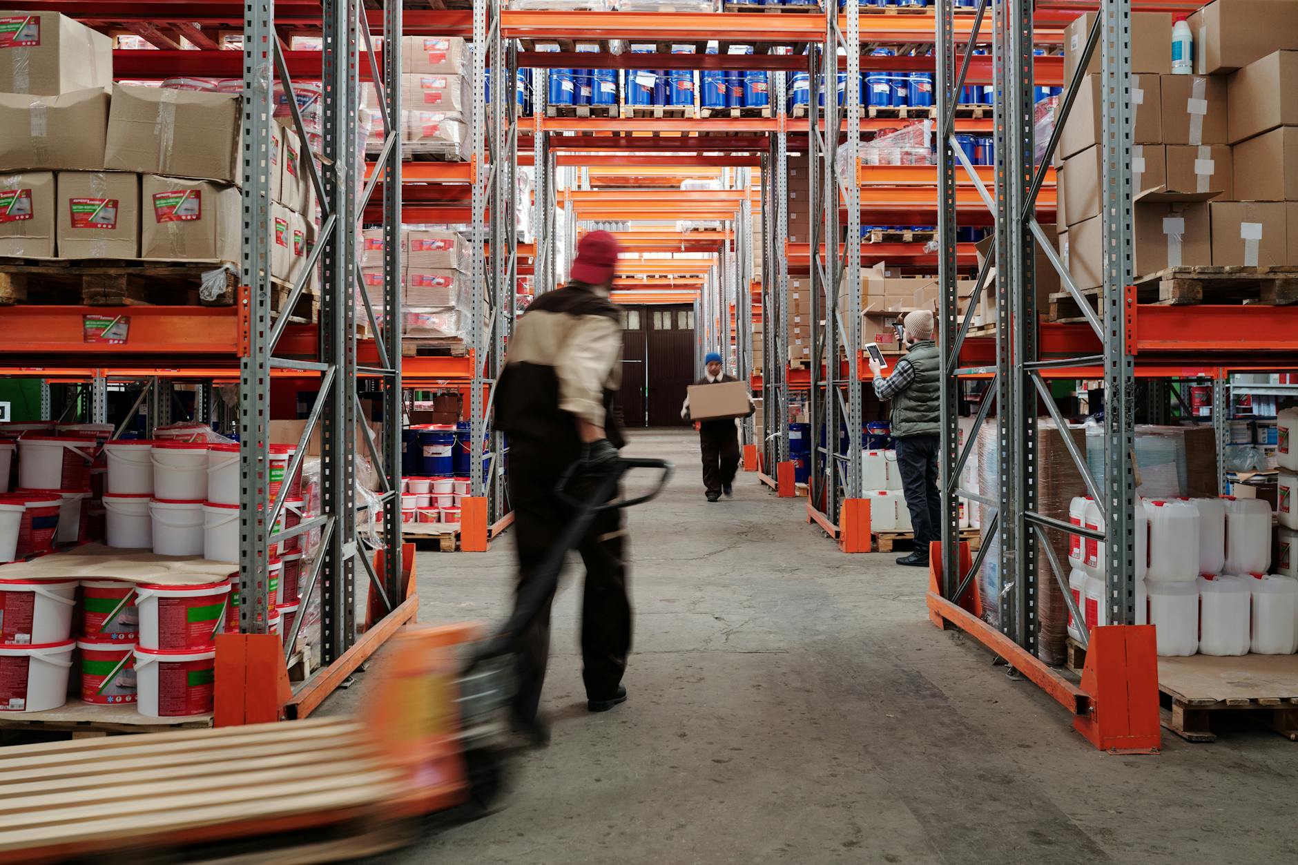 A vibrant, dynamic image showcasing human-robot collaboration in a warehouse. A human worker is interacting naturally with an AMR that is carrying a bin of goods, perhaps receiving instructions or handing over an item. The scene is well-lit, emphasizing safety and efficiency, with a futuristic yet practical aesthetic.