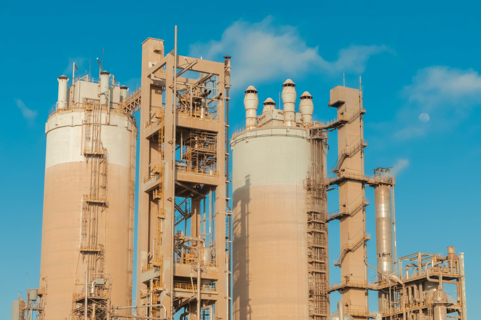 A sophisticated biorefinery complex at sunset, showcasing advanced industrial architecture with plumes of clean steam rising. The scene emphasizes innovation and sustainable energy production on a large scale.