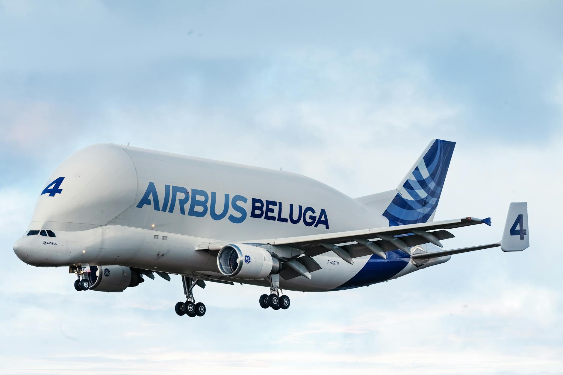 A visionary concept rendering of a large, twin-aisle commercial aircraft with redesigned wings and fuselage, clearly indicating integrated liquid hydrogen storage tanks. The aircraft is shown in flight, symbolizing a future of clean air travel.