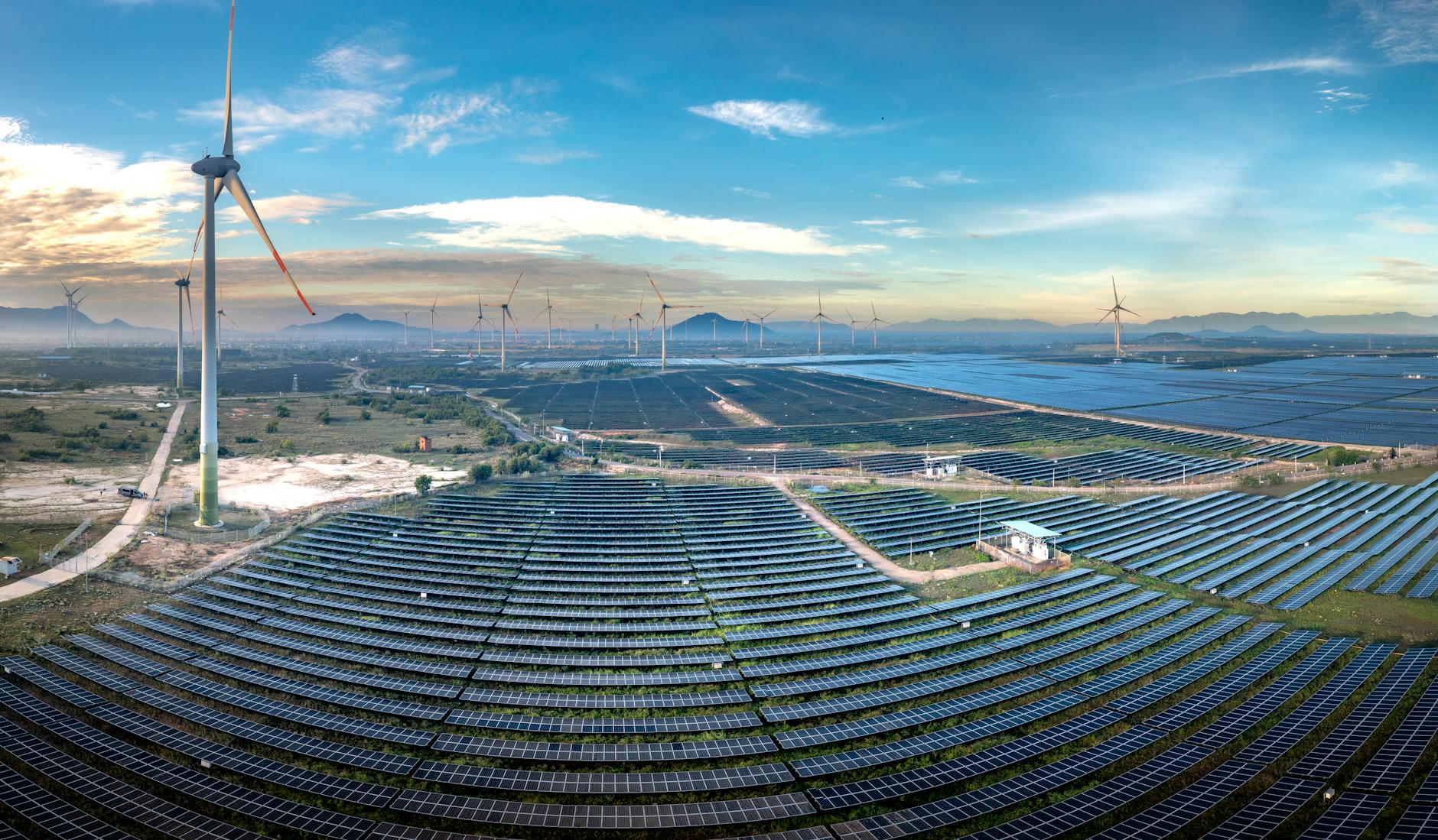 A panoramic view of a futuristic city skyline powered by a clean energy grid, with visible signs of advanced LDES infrastructure integrated into the urban landscape.
